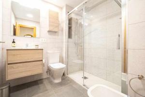a bathroom with a shower and a toilet and a sink at Ambar Playa San Lorenzo in Gijón