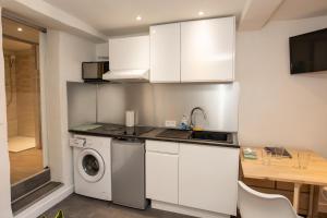 a kitchen with white cabinets and a washing machine at Parfum mimosa in Grasse