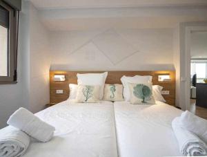 a bedroom with a large white bed with white pillows at El Séptimo Apartamento in Gijón