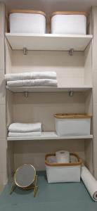 armadio con ripiani bianchi, specchio e asciugamani di Miramar Beach Apartment a El Médano
