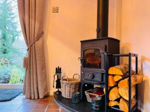 a stove with a pile of bread in a room at Luxurious Riverside Cottage in Snowdonia National Park in Tanygrisiau