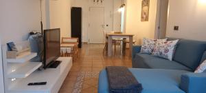 un soggiorno con divano blu e TV di Miramar Beach Apartment a El Médano