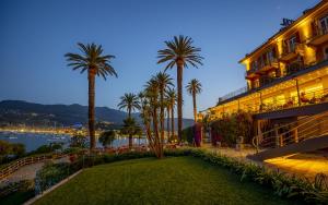 a resort with palm trees and a lawn in front of a building at Hotel Continental in Santa Margherita Ligure