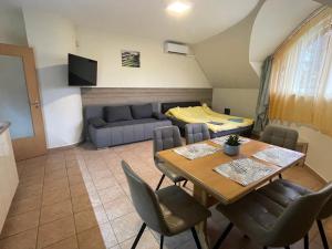 sala de estar con mesa y sofá en Künszler Apartmanház en Zamárdi