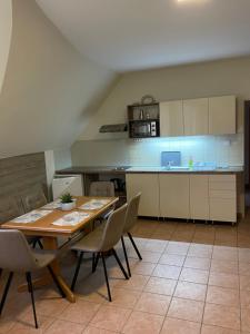 una cucina e una sala da pranzo con tavolo e sedie di Künszler Apartmanház a Zamárdi