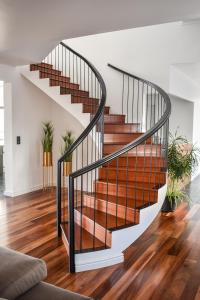 a spiral staircase in a living room with wood floors at Volcanic Charming House in Ribeira Grande