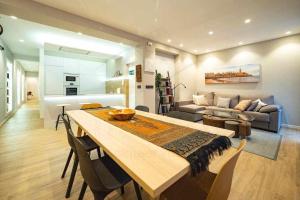 cocina y sala de estar con una gran mesa de madera. en Dindurra Apartamento en Gijón