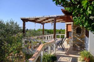 a patio with a wooden pergola and chairs at Villa Aelia in Alonnisos