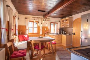 a kitchen with a table and a couch in a room at Loya Chalet WILD32 in Oberau