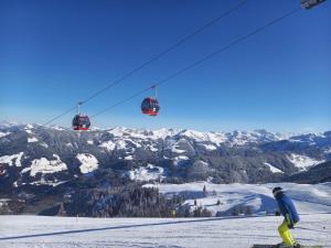 a person riding a ski lift on a snow covered mountain at Loya Chalet WILD32 in Oberau