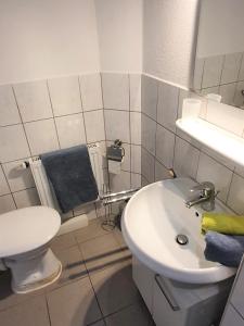 a bathroom with a white toilet and a sink at Apartment Nordseeblick in Norddeich