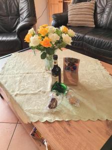 a table with a bottle of wine and flowers on it at Ferienhaus Nordseeblick in Norddeich