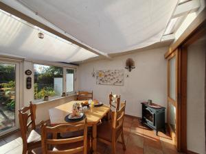 uma sala de jantar com uma mesa de madeira e cadeiras em Ferienhaus Nordseeblick em Norddeich