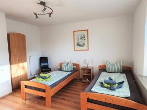 1 dormitorio con 2 camas individuales y TV en Ferienhaus Nordseeblick, en Norddeich