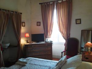 Valros的住宿－L'ORANGERIE Chambres d'hotes de charme，一间卧室配有一张床、一个梳妆台和一扇窗户。