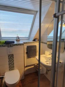 a bathroom with a sink and a toilet and a window at Ferienhaus Nordseeblick in Norddeich