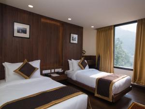 a hotel room with two beds and a window at Indra Mandala,Gangtok - AM Hotel Kollection in Gangtok
