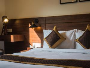 a bedroom with a large bed with a wooden headboard at Tree of Life Indra Mandala Hotel, Gangtok in Gangtok