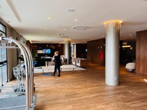 a woman walking through a lobby of a building at MRG- Exclusive Gramado Loft 1D - 10 minutos do Centro in Gramado