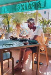 a man sitting at a table with a plate of food at La Paix Hôtel , Restaurant in Taghazout