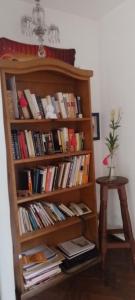 a book shelf filled with books next to a table at Habitaciones en el centro de Rosario in Rosario