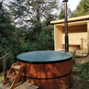 una bañera de hidromasaje en un barril fuera de una cabaña en Complejo Kari Mapu Park en Pucón