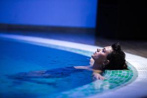 Eine Frau, die im Schwimmbad liegt. in der Unterkunft Castello Mare All Inclusive Resort in Batumi