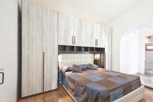 a bedroom with a large bed with wooden cabinets at Villa Isola Rossa in Isola Rossa