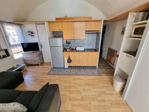 uma cozinha com um sofá e uma cozinha com um frigorífico em Bellyenmer Gruissan em Gruissan
