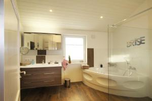 Un baño con una bañera grande y un lavabo. en Ferienhaus Skagen, en Steinbergkirche