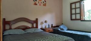 une chambre avec deux lits et une fenêtre dans l'établissement Chalés Alto da Serra 1, à Campos do Jordão