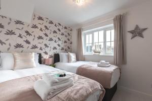 1 dormitorio con 2 camas y ventana en Chichester retreat house with free parking, en Chichester