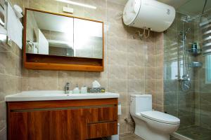 a bathroom with a toilet and a sink and a mirror at 3-Bedroom Apartment in Tema - Chez Akwasi in Tema