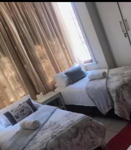 sypialnia z 2 łóżkami i oknem w obiekcie Fj's place w mieście Durban