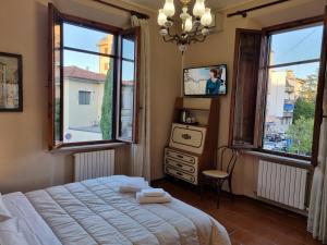 1 dormitorio con 1 cama, TV y ventanas en Villa Rismondo, en Pisa