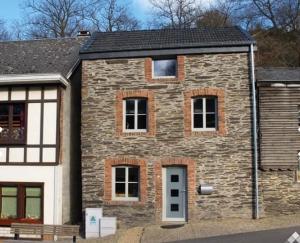 an old stone house with a white door at Le repaire des amoureux in La Roche-en-Ardenne