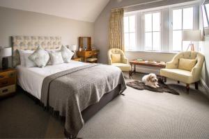 a bedroom with a bed and a dog laying on the floor at The Porlock Weir Hotel in Porlock