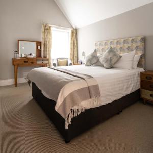 a bedroom with a large bed with a mirror at The Porlock Weir Hotel in Porlock