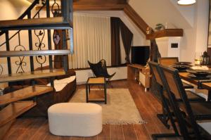 een woonkamer met een trap en een tafel en stoelen bij Garnet Star Apartments, Kopaonik, apartman br.3. in Kopaonik
