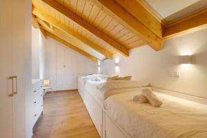 2 camas en una habitación con techos de madera en Duplex Campodios Villanua, en Villanúa