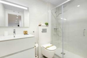 y baño blanco con aseo y ducha. en Duplex Campodios Villanua en Villanúa