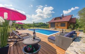 una terraza con piscina y una mesa con sombrilla en Kuća za odmor Josip, en Gospić