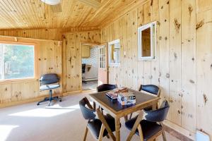 Pokój z drewnianą ścianą ze stołem i krzesłami w obiekcie Bayview Retreat w mieście Bowdoinham