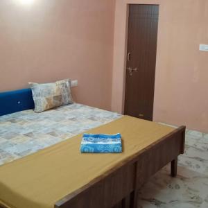 a bed in a room with a wooden table at Axar Complex (1BHK) in Anand