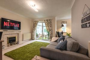 a living room with a couch and a fireplace at Chichester retreat house with free parking in Chichester