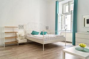 a white bedroom with a crib and a table at 4 Charming Apts. Perfect for 19 persons (6BRs) in Vienna
