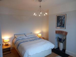 切爾滕納姆的住宿－Palsgrave Lodge，一间卧室配有一张大床,两盏灯