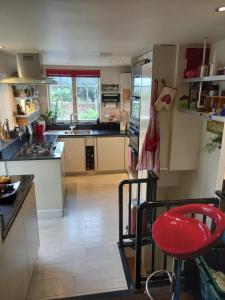 a kitchen with a red stool in the middle of it at Palsgrave Lodge in Cheltenham