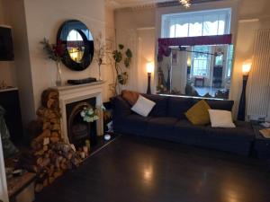 a living room with a couch and a fireplace at Palsgrave Lodge in Cheltenham
