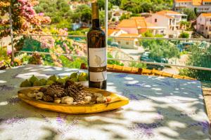 a bottle of wine and a plate of food on a table at Stone House Dioniz in Brnistrova